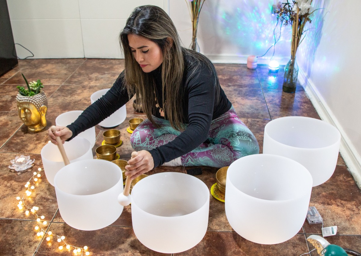 Bárbara tocando los cuencos de cuarzo sentada en el suelo